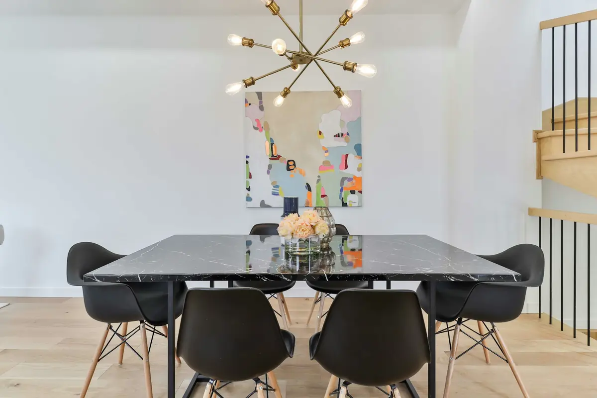 Contemporary dining room with a dark glass table and brass chandelier