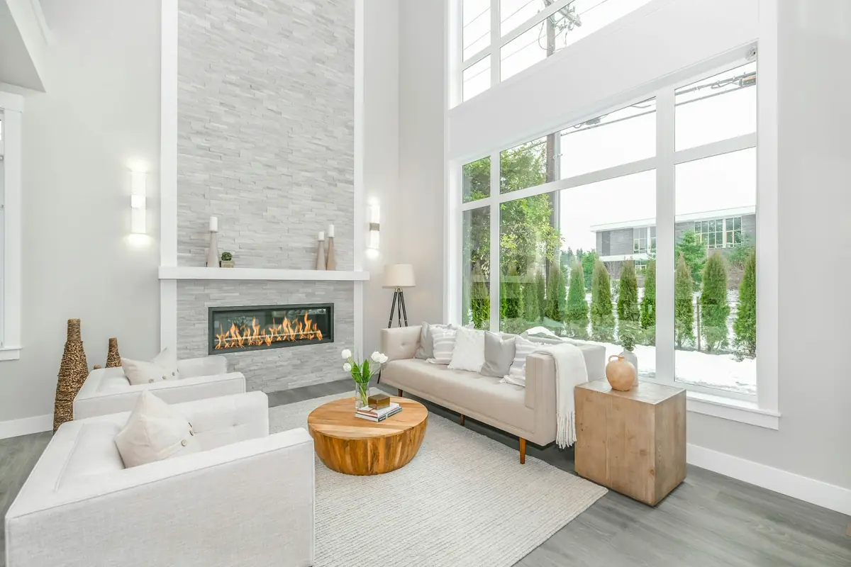 Light-filled living room with a tall stone fireplace wall