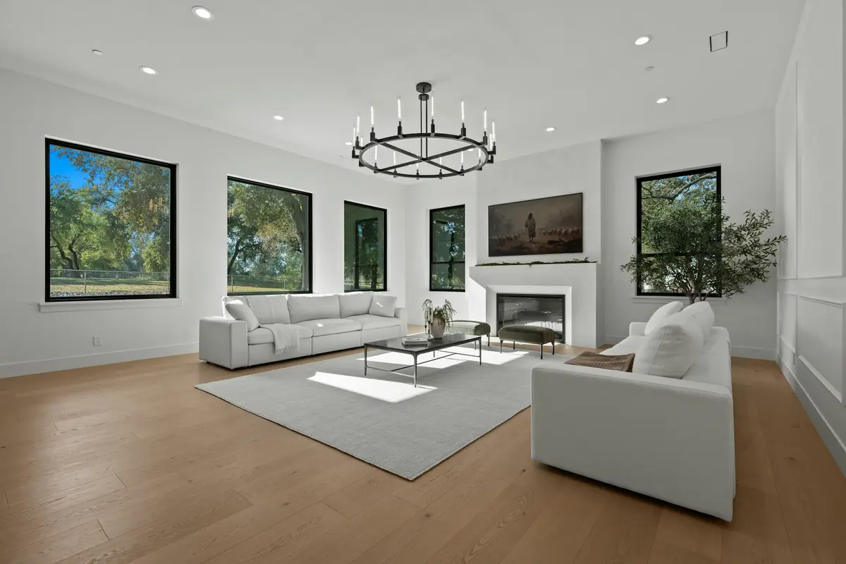 Open living room with wide-plank oak floors and black-framed windows